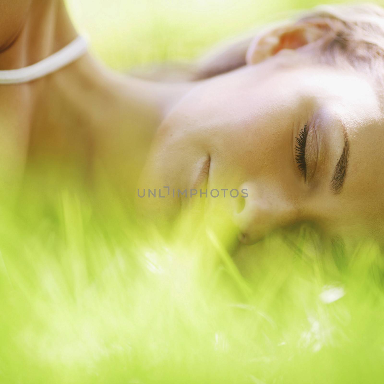 Beautiful young woman sleep on grass