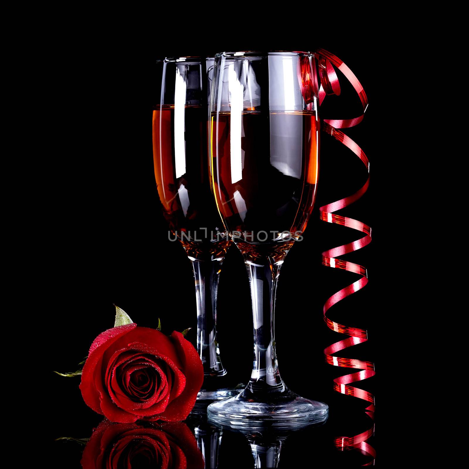Rose with glasses and a red tape Alcohol and flower. Glasses with drink and a red rose.