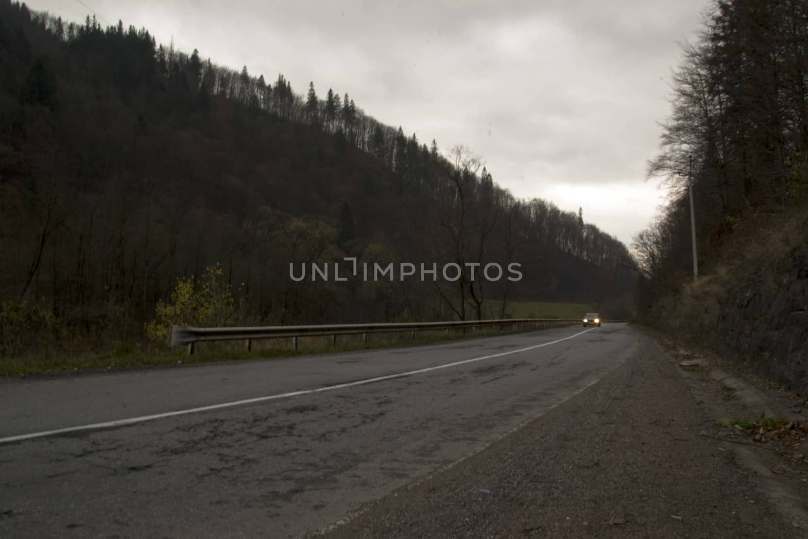 Car on a mountain road at dusk by Irene1601
