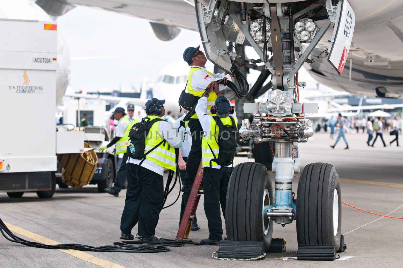 SINGAPORE - FEBRUARY 11: Ground crew connecting cables to Airbus A350 XWB prototype 003 at Singapore Airshow, Changi Exhibition Centre in Singapore on February 11, 2014.