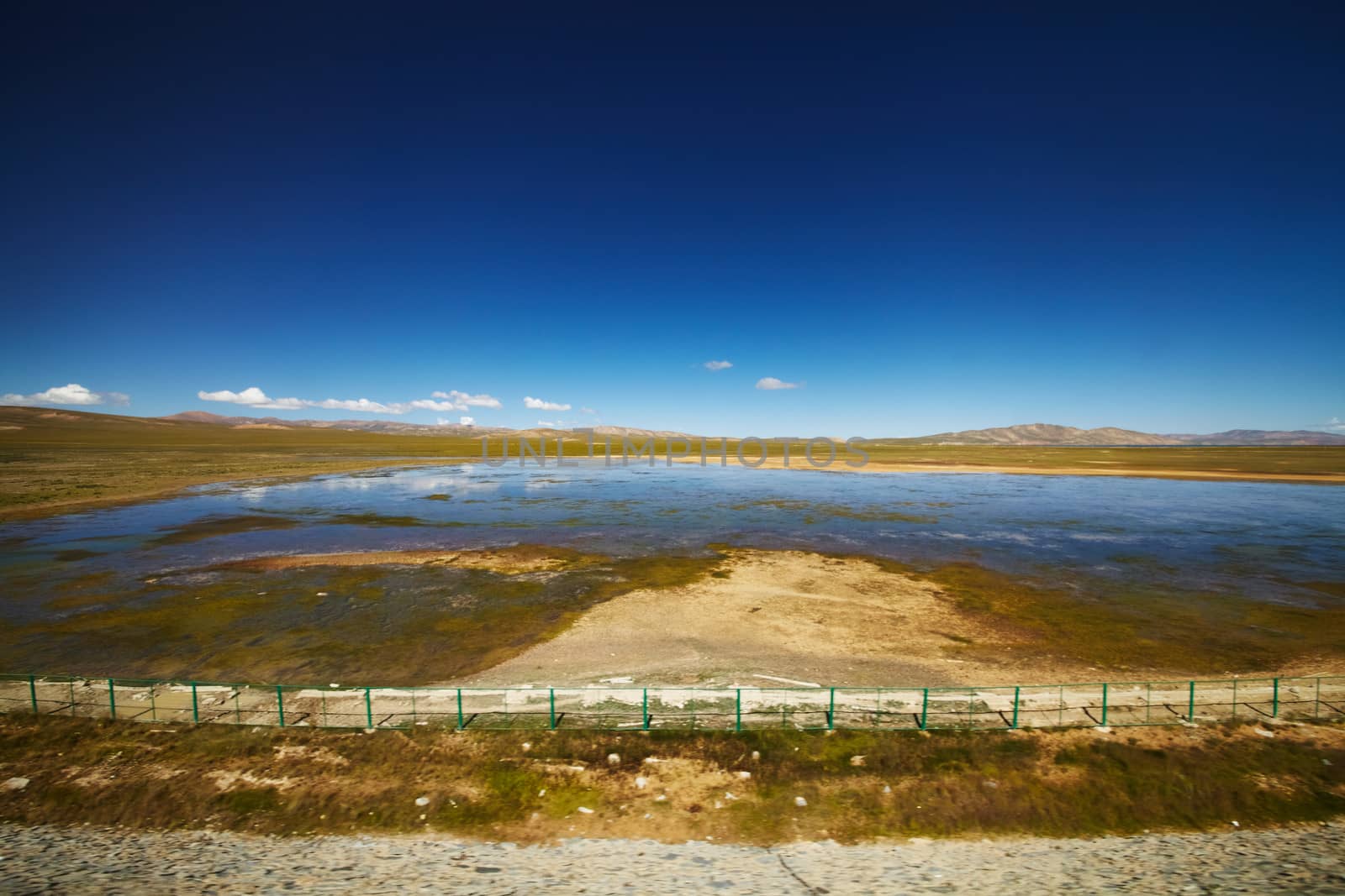 A view of clear blue lake with mountain landscape in the background at Tibetan Plateau