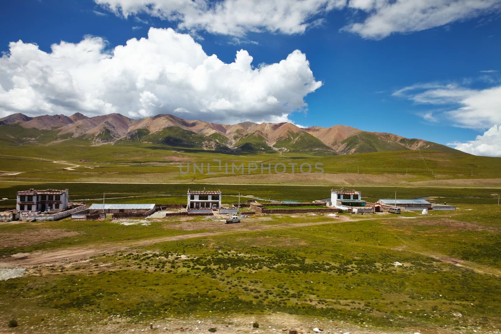 A Tibetan rural village in the outskirts.  Mountain landscape with cloudy sky