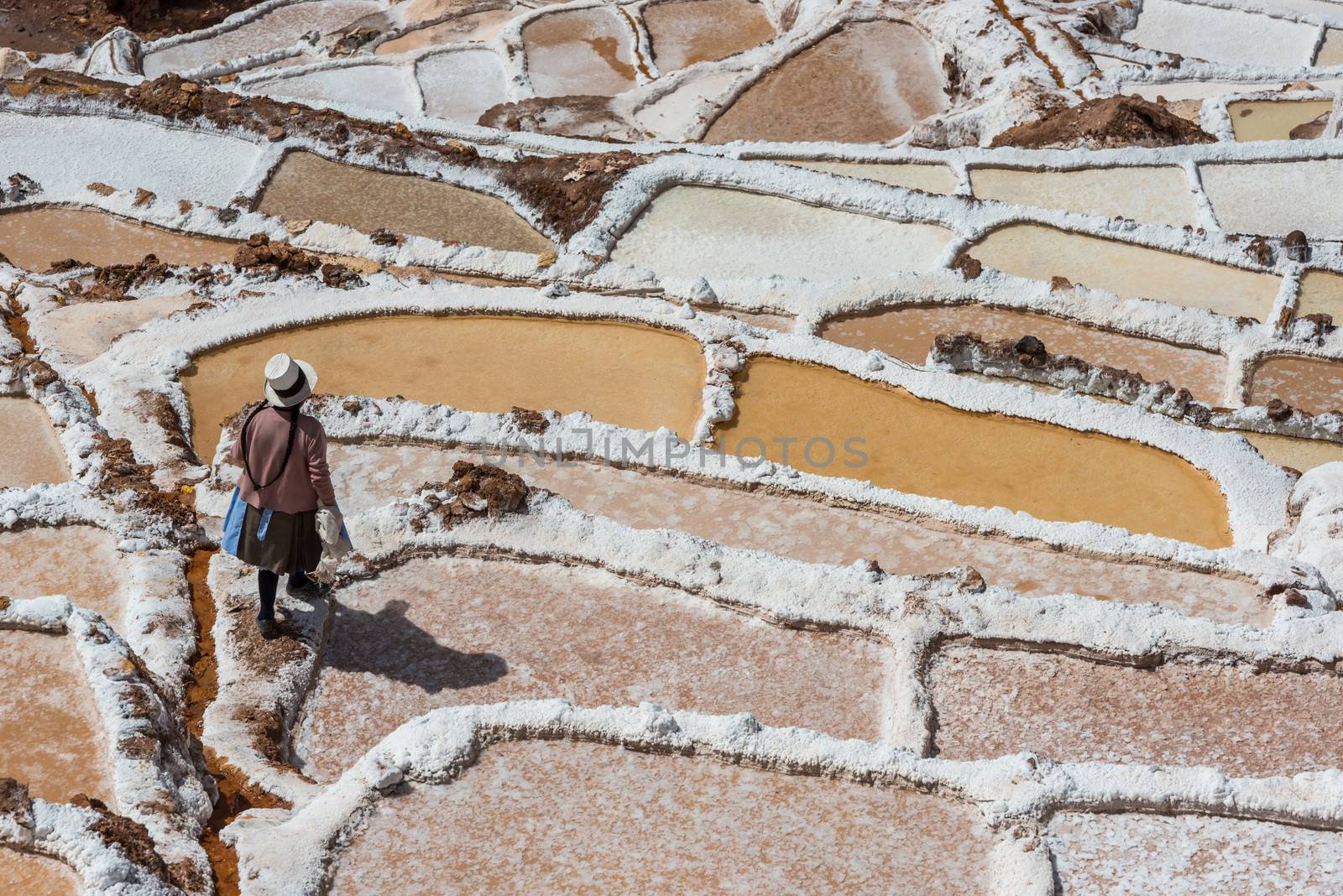 Maras, Peru - July 23, 2013: woman at Maras salt mines in the peruvian Andes at Cuzco Peru on july 23, 2013