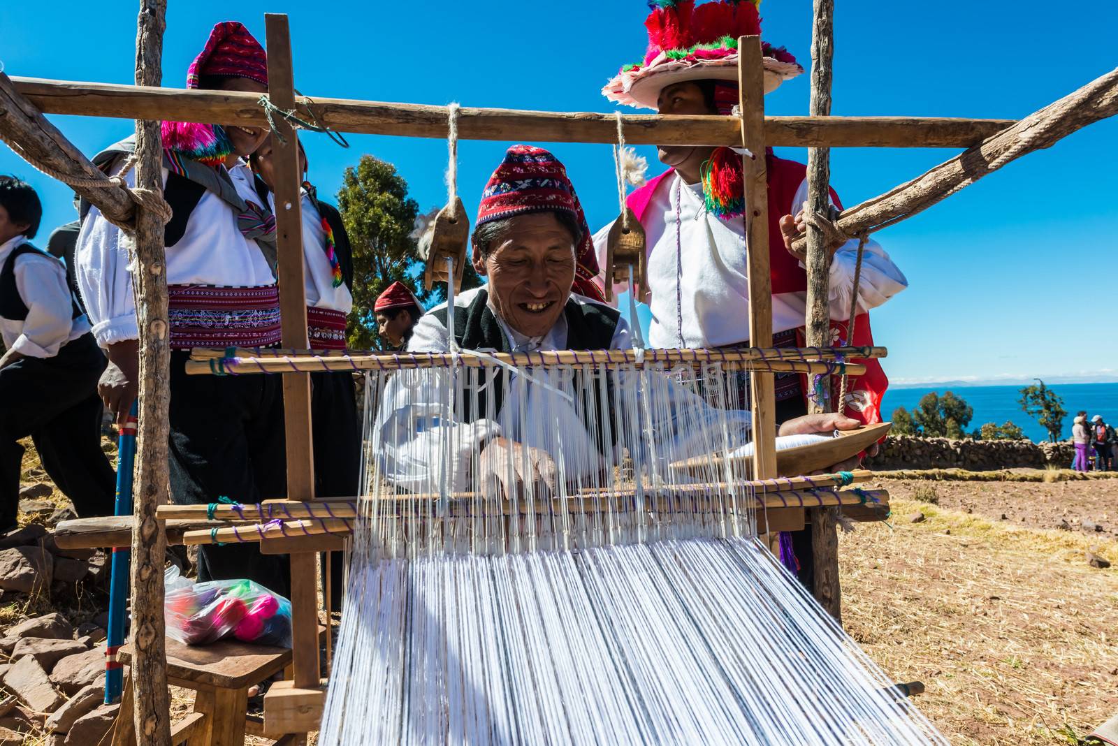 men weaving in the peruvian Andes at Puno Peru by PIXSTILL