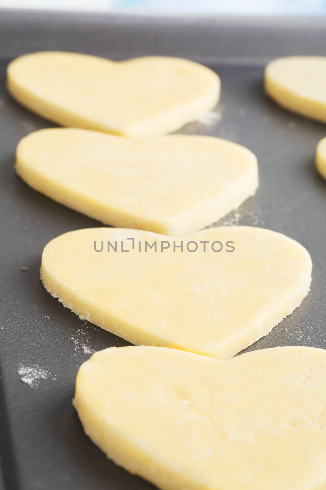 Heart shaped cookies on baking sheet ready for baking.