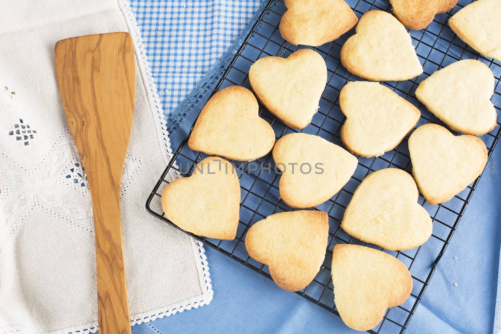 Fresh baked heart shaped cookies on cooling rack.