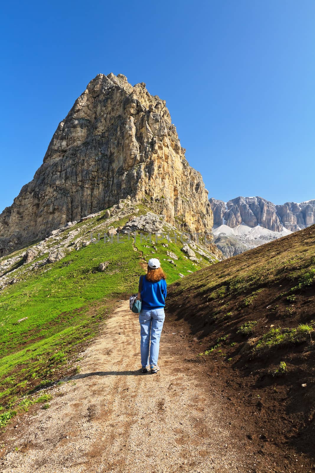 hiker plays trekking over Pordoi pass, Trentino, Italy