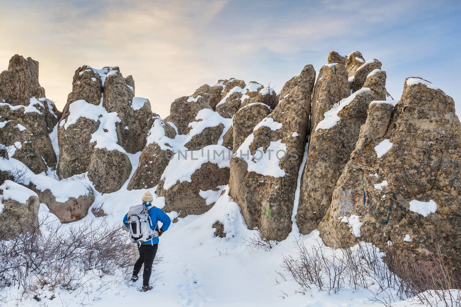 a hiker in Natural Fort sculpted from sandstone (Oligocenne White River Formation) by erosion - geologic and historic landmark on prairie in northern Colorado, winter scenery