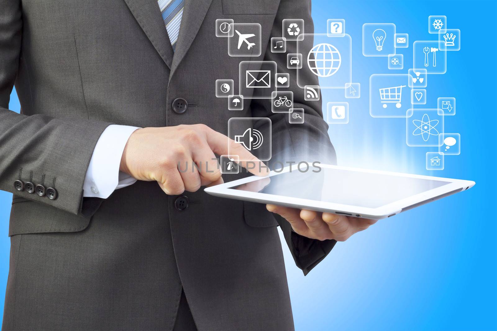 Businessman in a suit holding a tablet computer. Application icons are emitted from the tablet