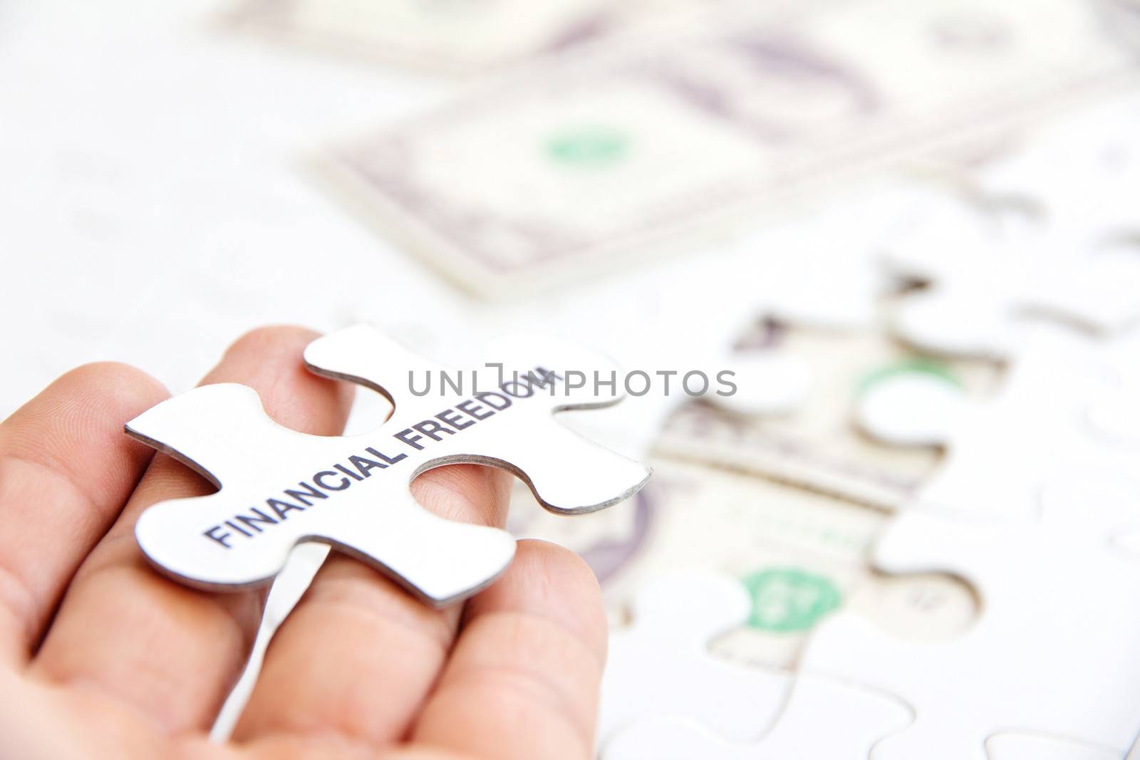 hand holding a puzzle piece, financial freedom concept