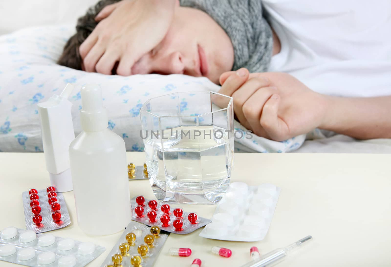 Sick Young Man sleeps with Pills on foreground. Focus on the Pills