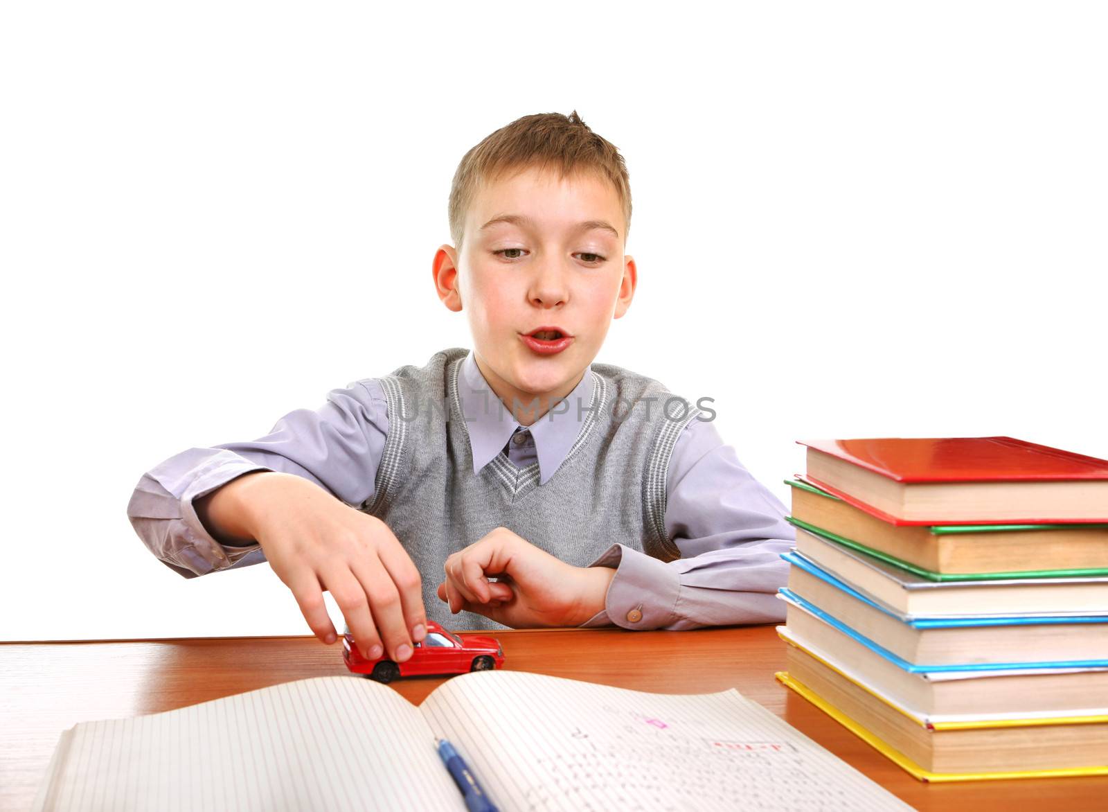 Schoolboy plays with a Toy on the School Desk on the white background