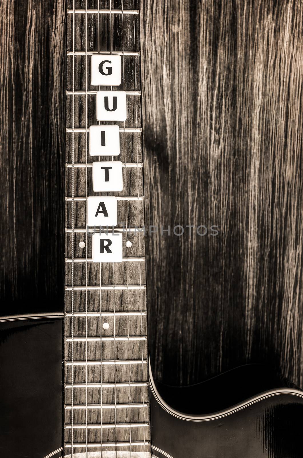 Acoustic guitar in vintage style on wood texture background