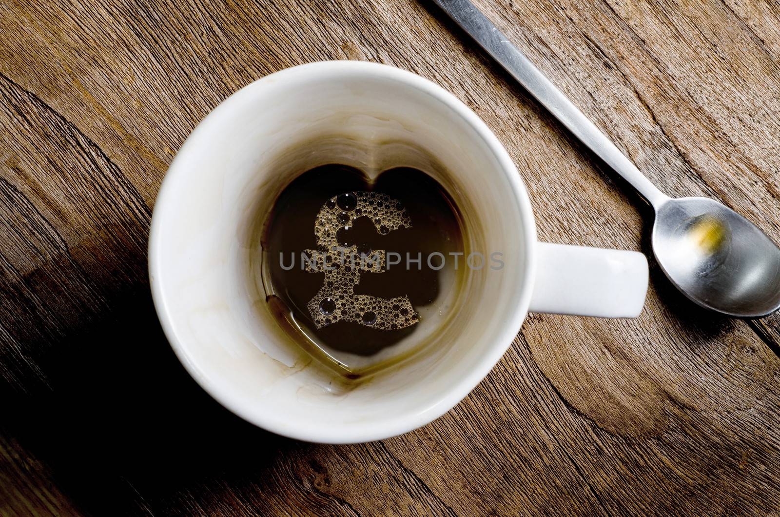 A Pound Sterling sign  this can serve as a concept for expensive coffee, caffeine addiction etc. 
and hands holding a cup of hot coffee