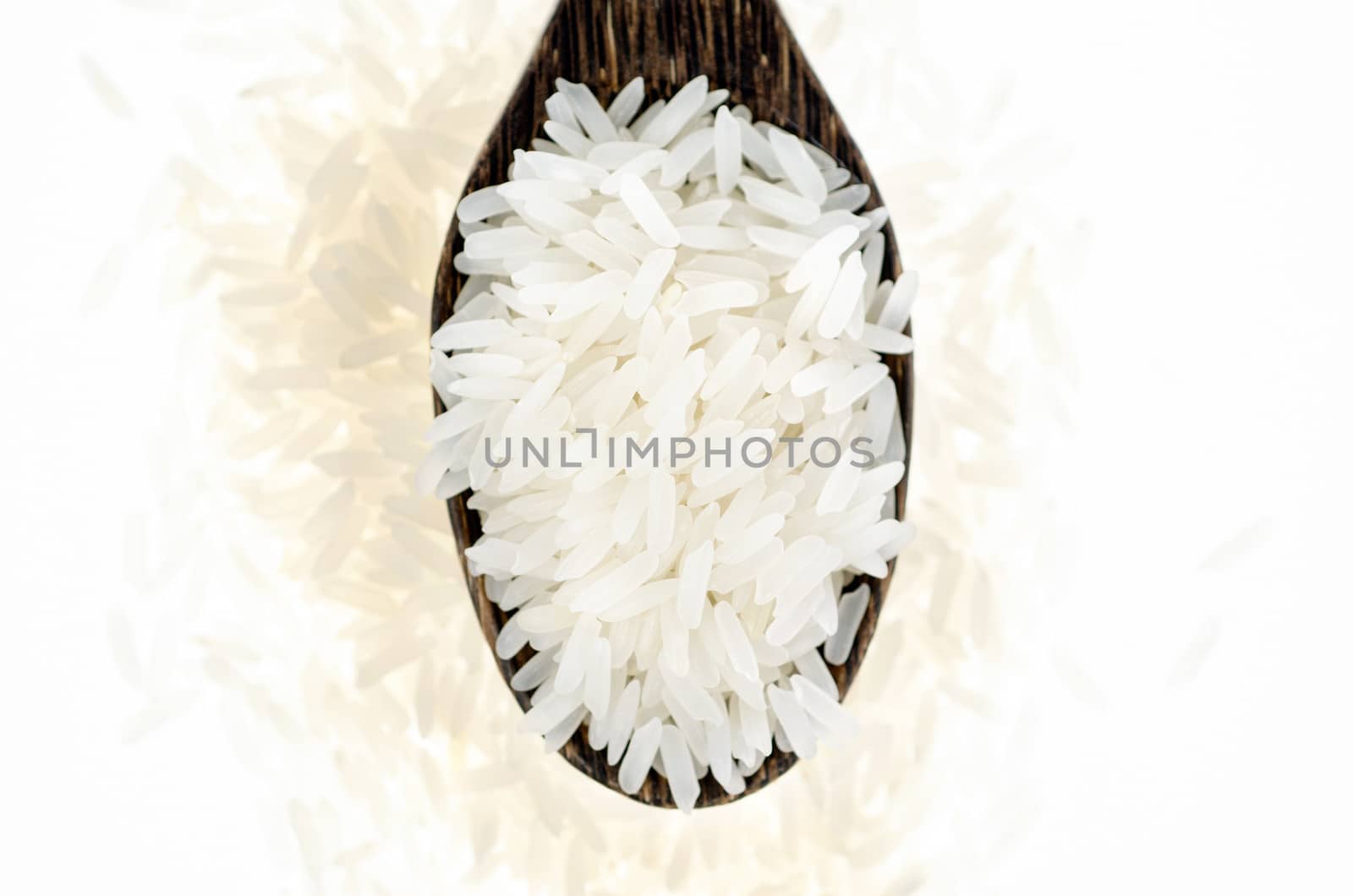 Rice grain in wooden spoon on white background by 9george