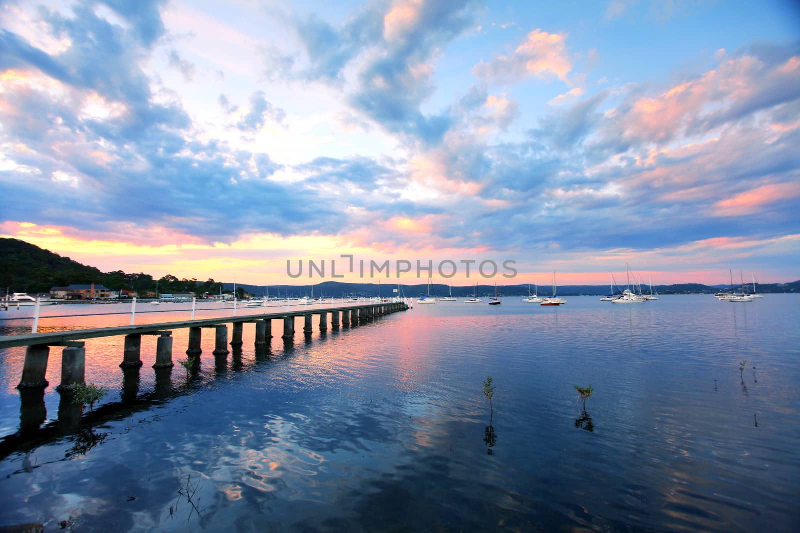 Saratoga sunset, jetty wharf and yachts moored at Saratoga on the Central Coast, Australia