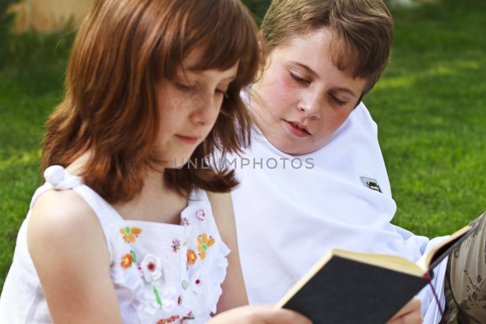 Teen.Portrait of cute kids reading books in natural environment