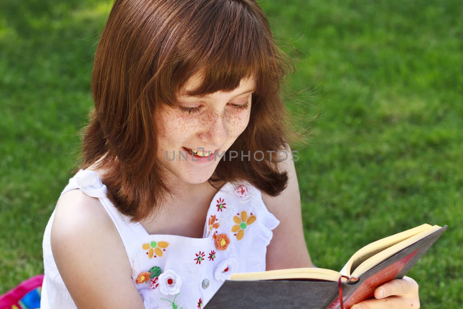 Young beautiful girl reading a book outdoor by FernandoCortes