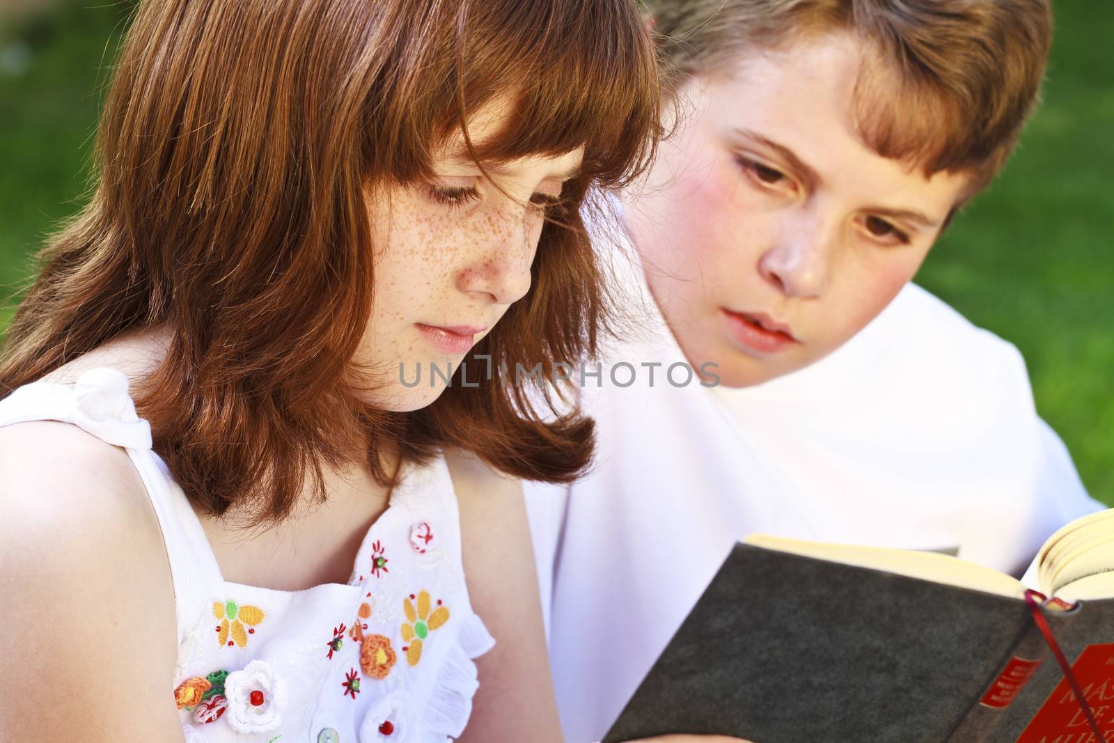 Teen.Portrait of cute kids reading books in natural environment by FernandoCortes