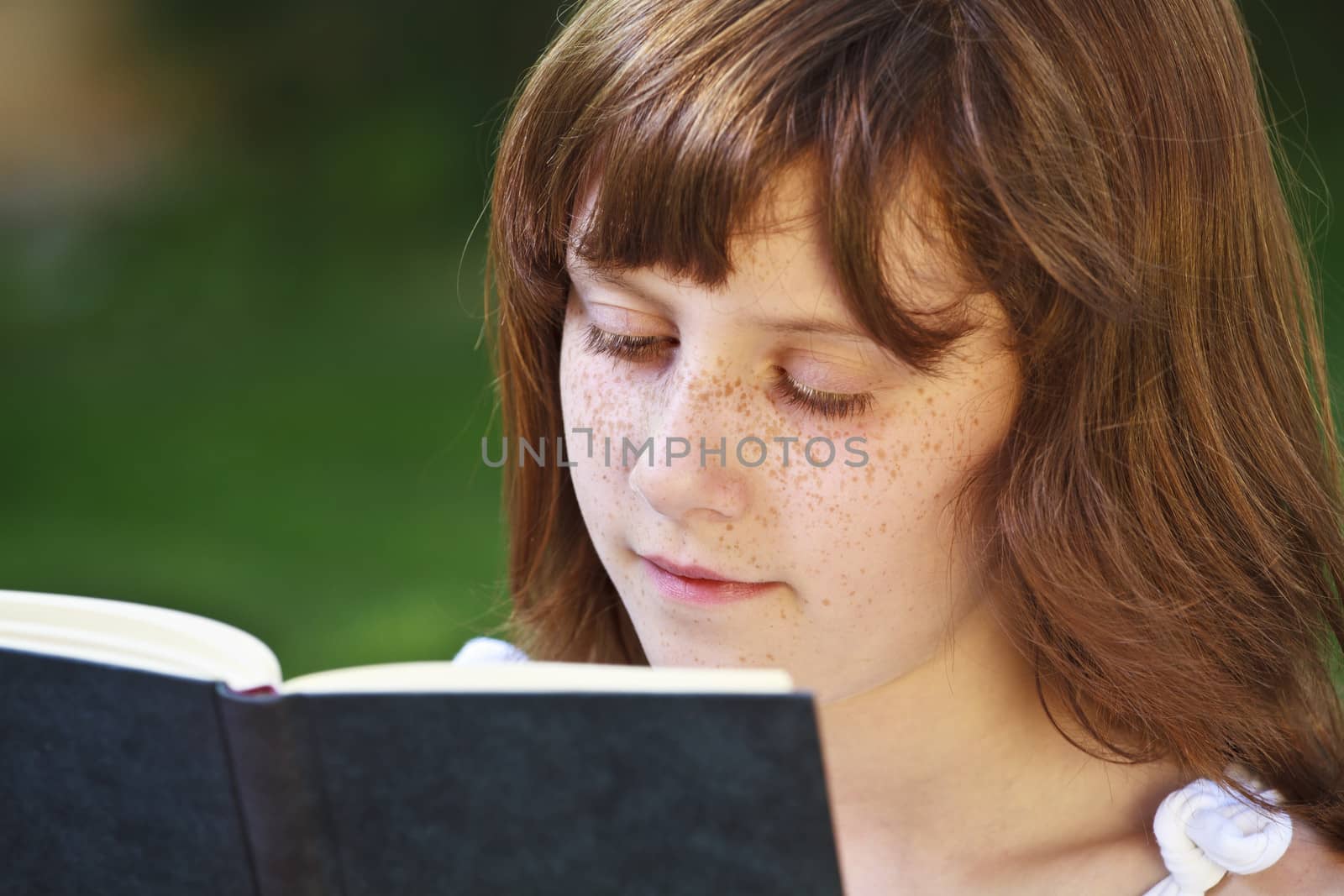 Read.Young beautiful girl reading a book outdoor by FernandoCortes