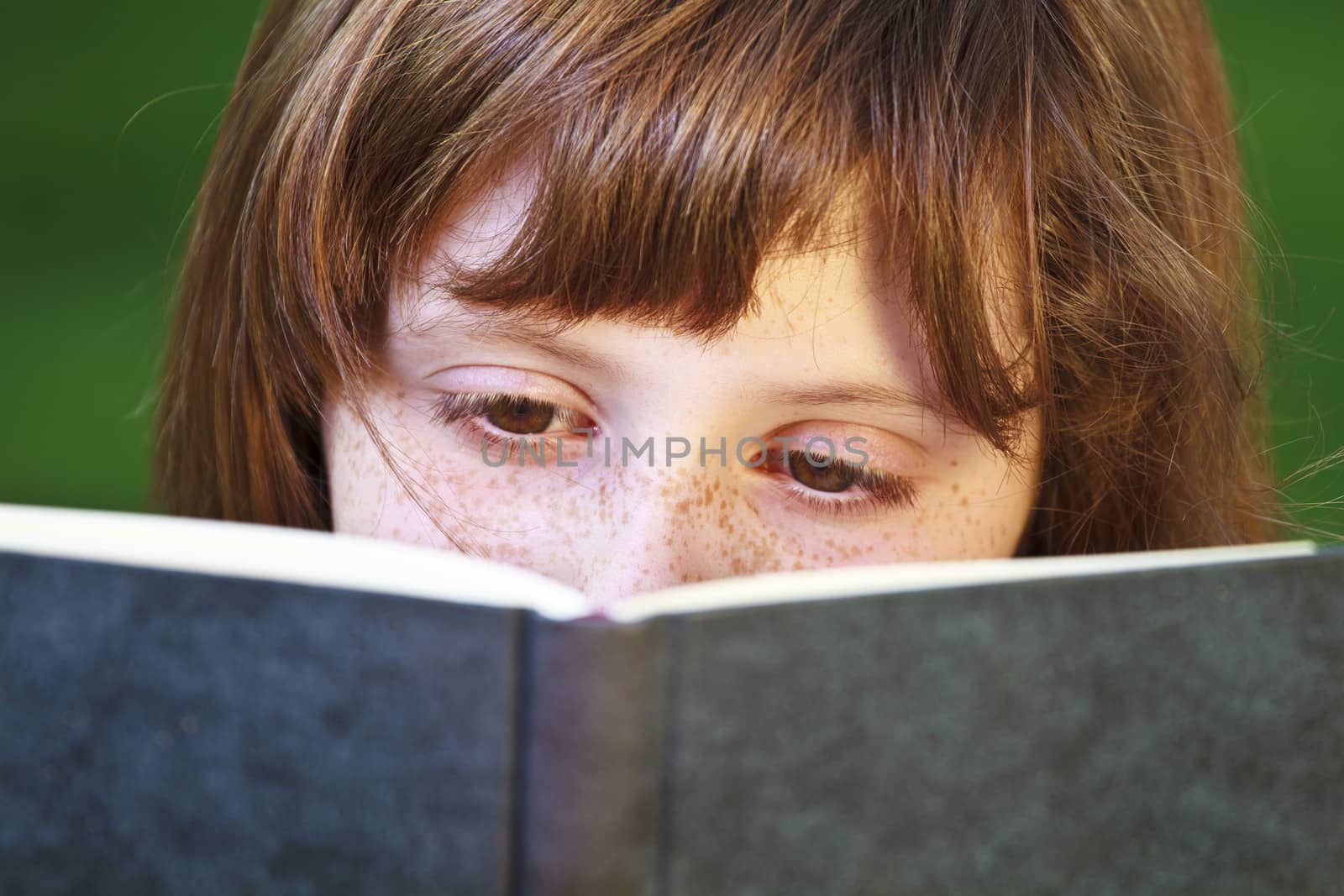 Young beautiful girl reading a book outdoor by FernandoCortes