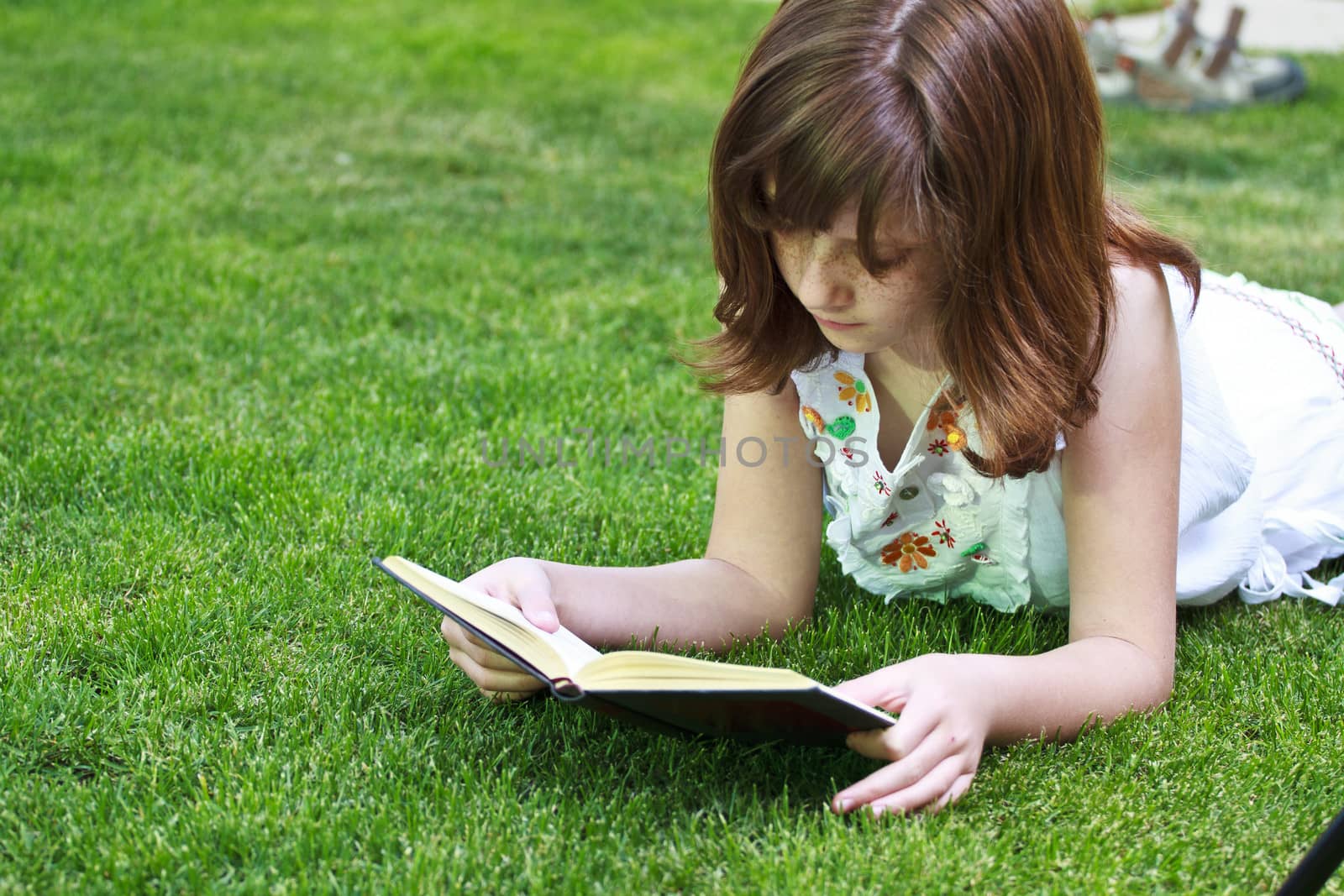 Read.Young beautiful girl reading a book outdoor by FernandoCortes