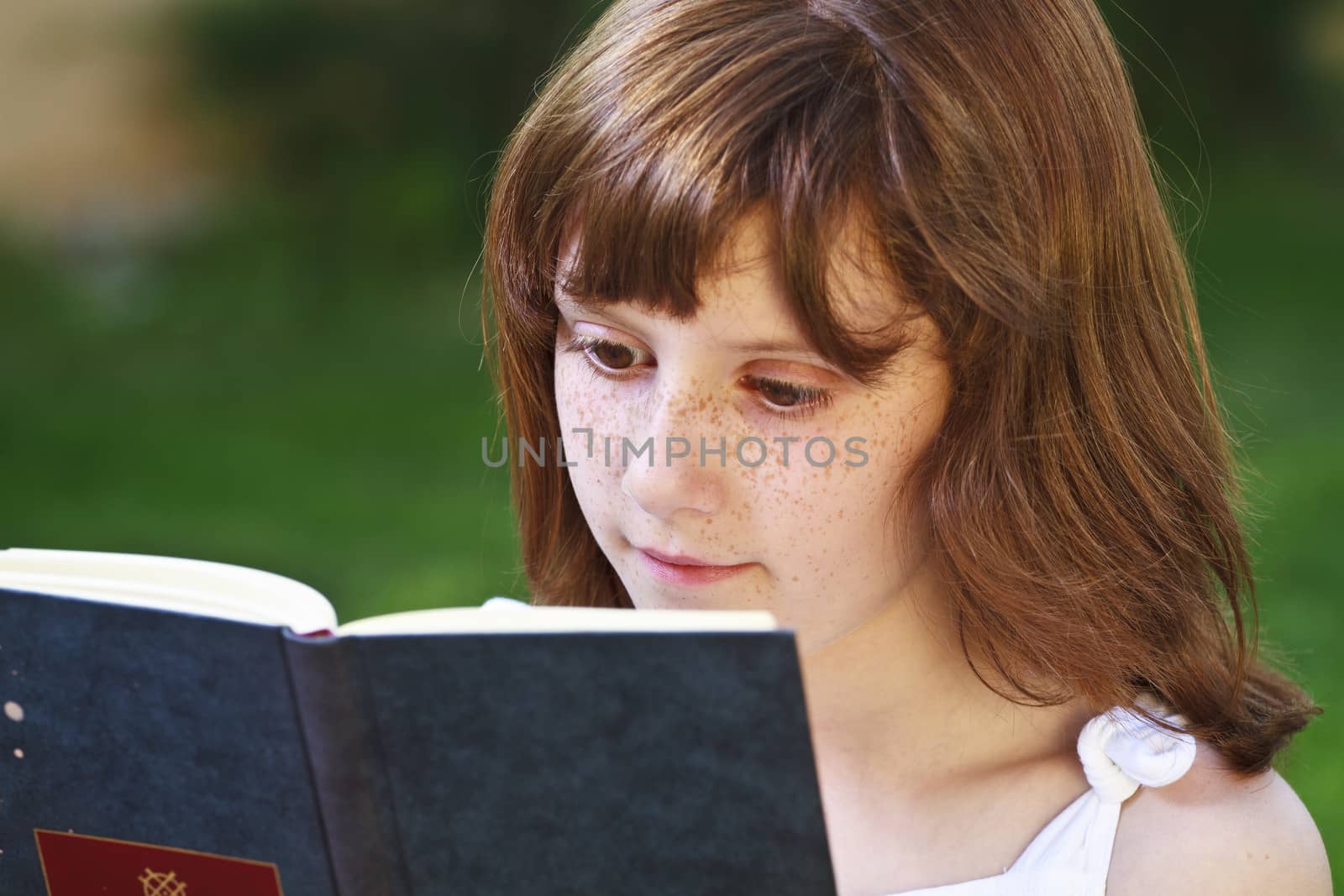 Literature.Young beautiful girl reading a book outdoor by FernandoCortes