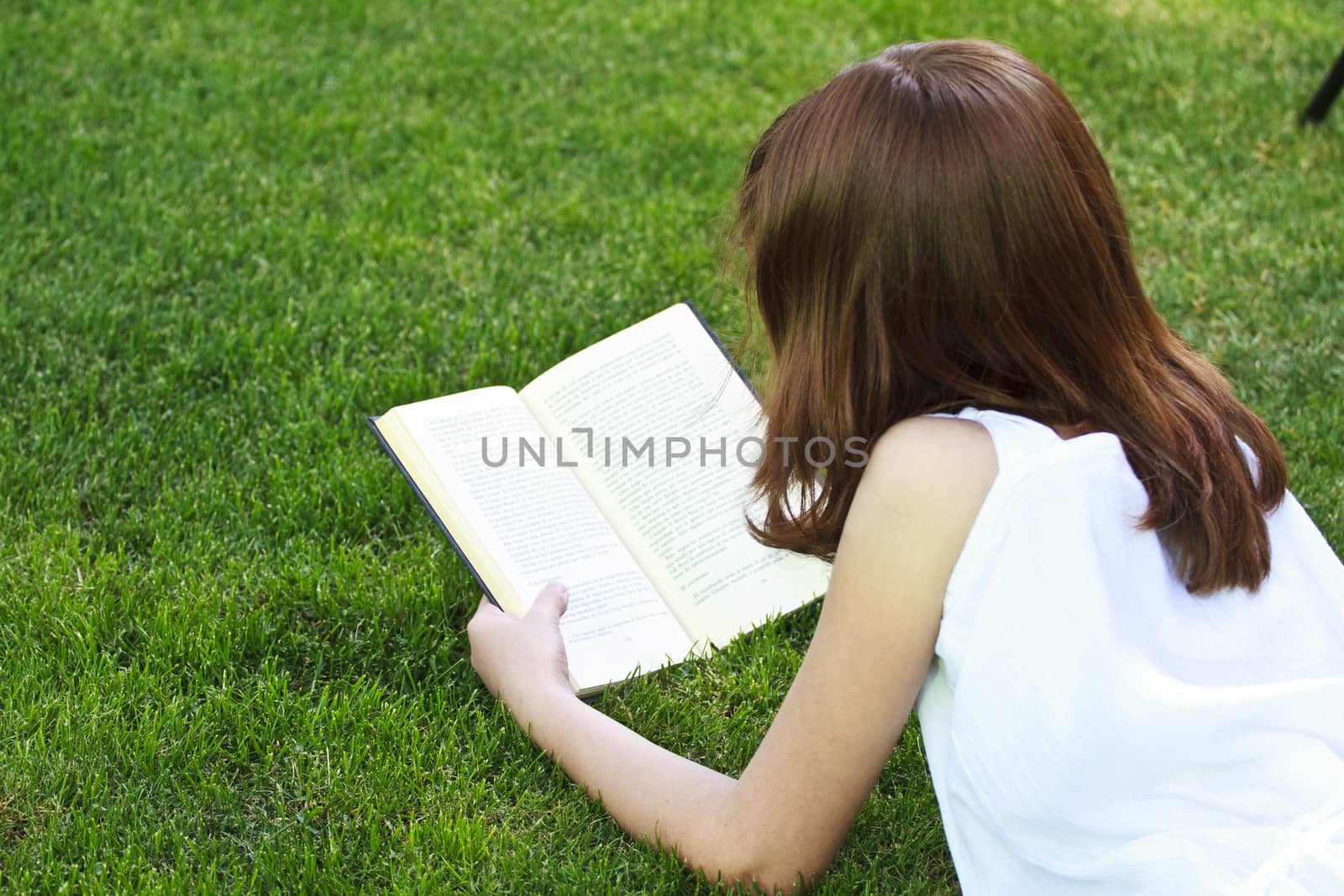 Student.Young beautiful girl reading a book outdoor by FernandoCortes
