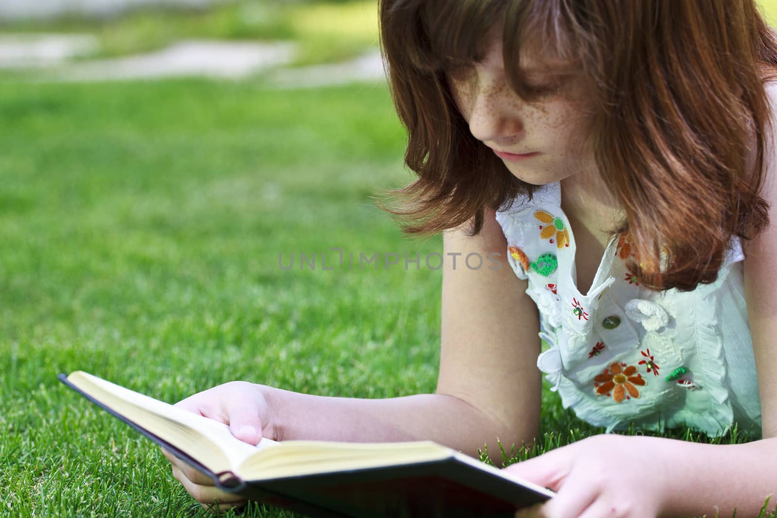 Study.Young beautiful girl reading a book outdoor