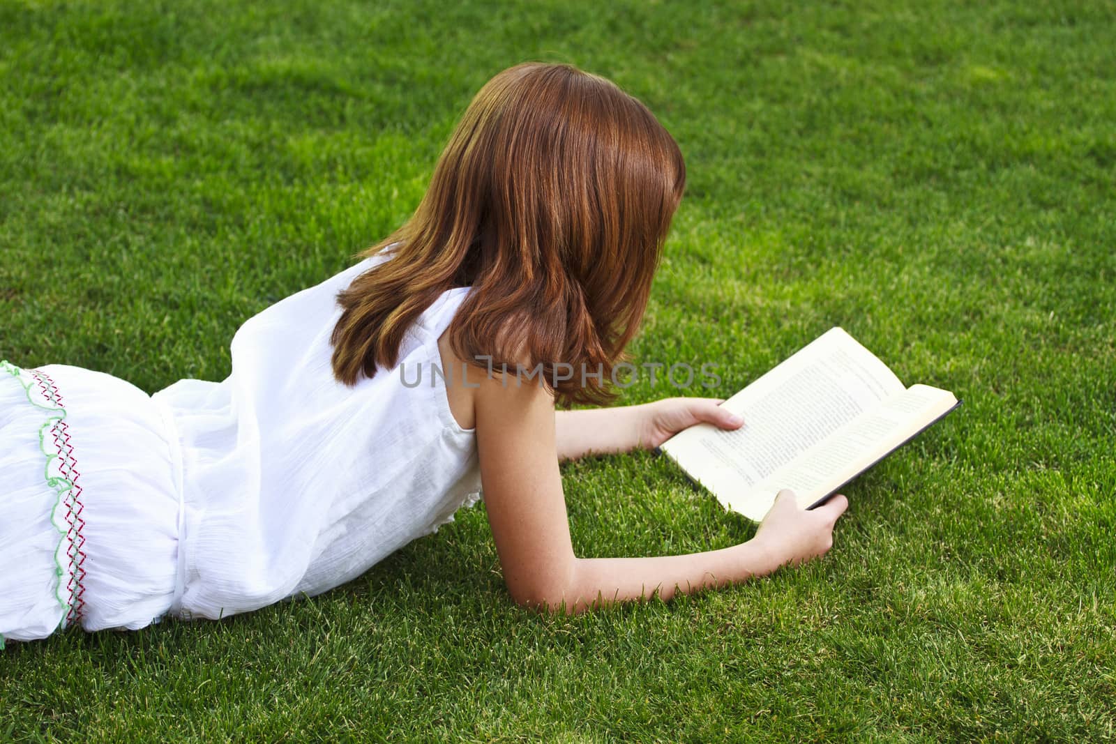 Schoolgirl.Young beautiful girl reading a book outdoor by FernandoCortes