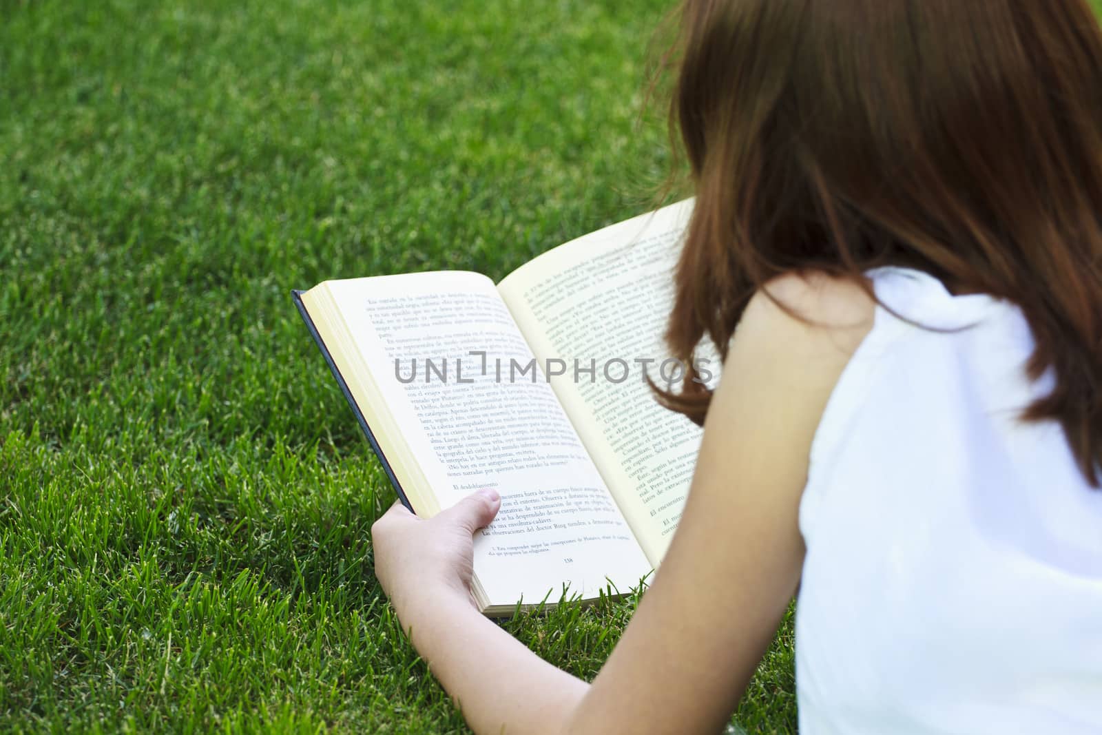 Student.Young beautiful girl reading a book outdoor by FernandoCortes