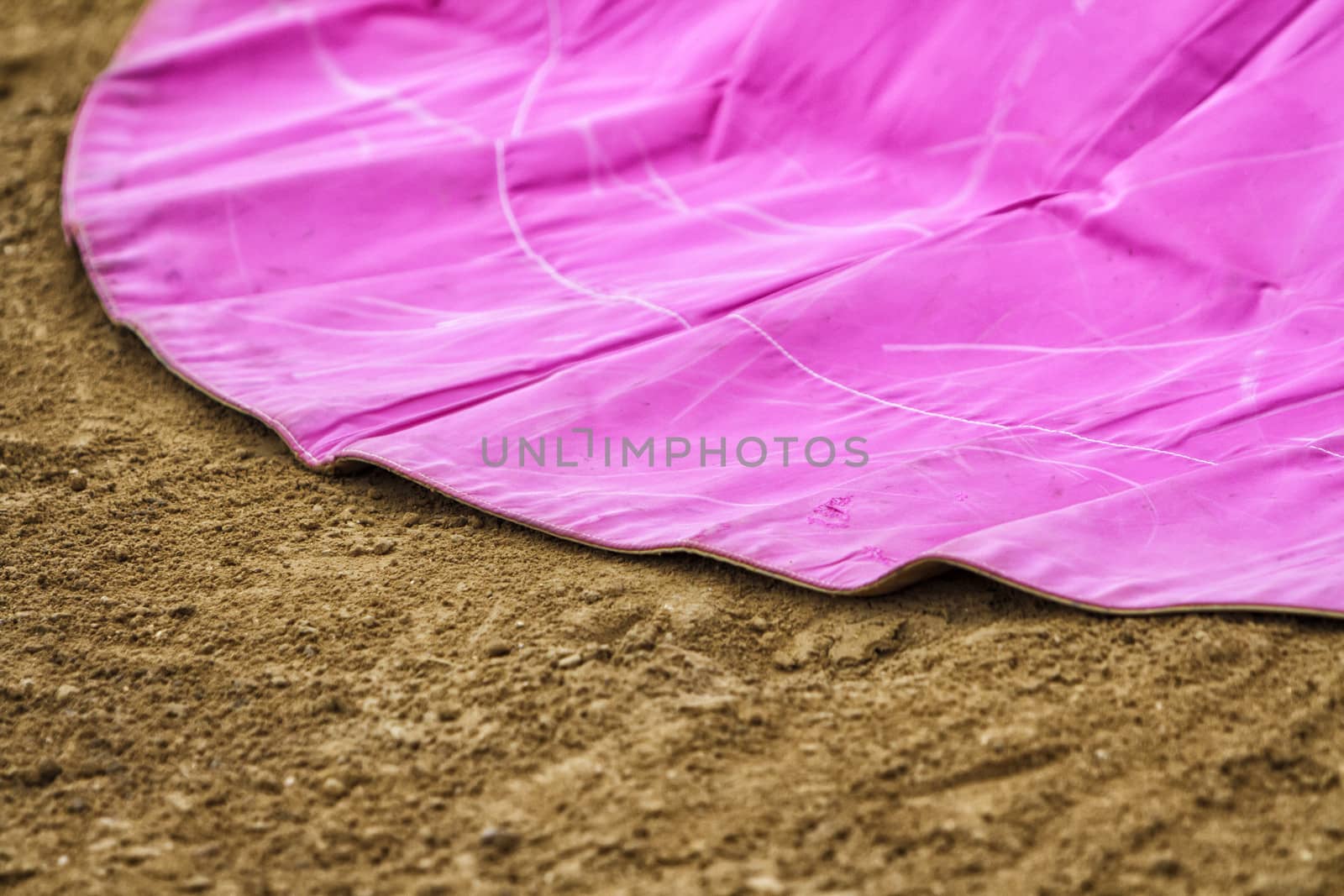 closed up of a cape of fighting of cloth of the canvas of pink color on the sand
