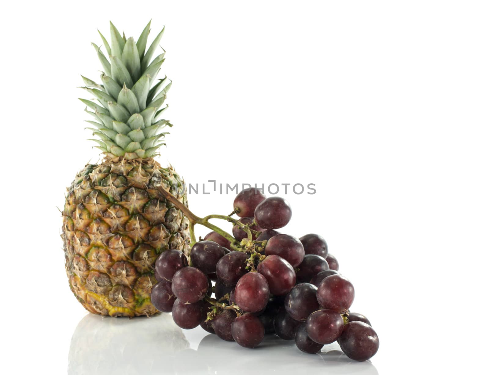 pineaple and red grapes isolated on white