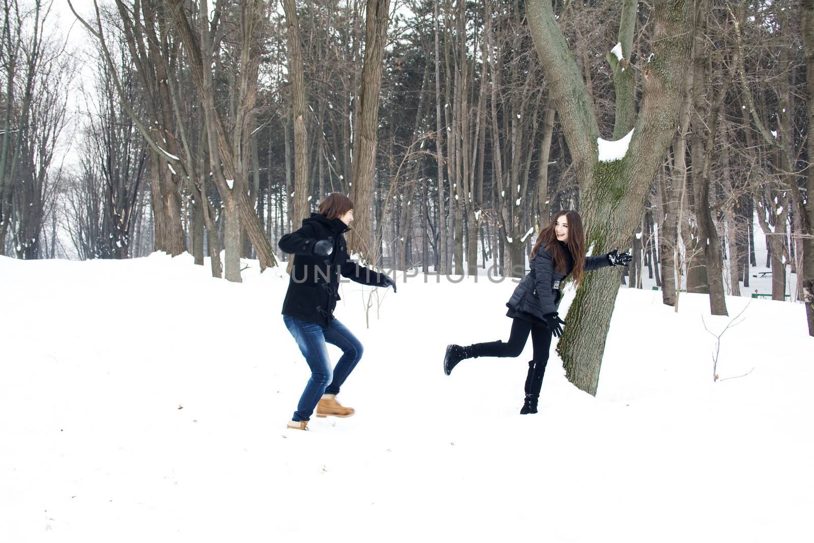 Young couple having fun in the snow laughing