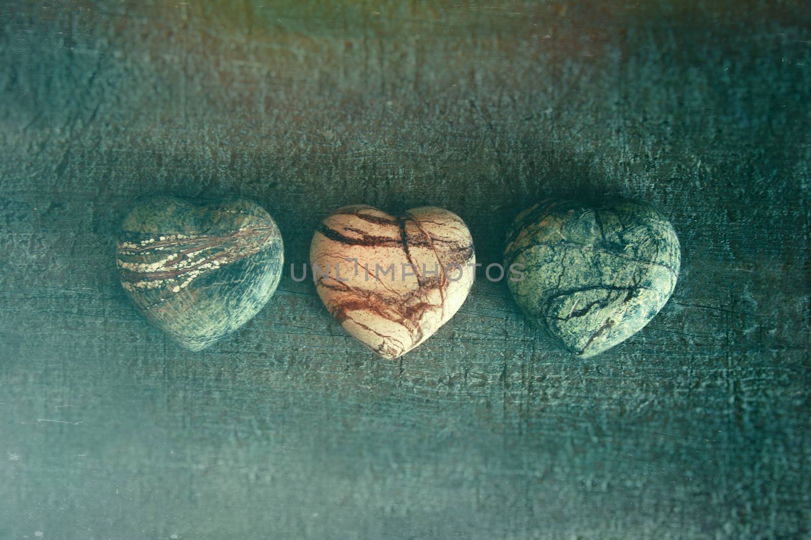 Three stone hearts on wood by Sandralise