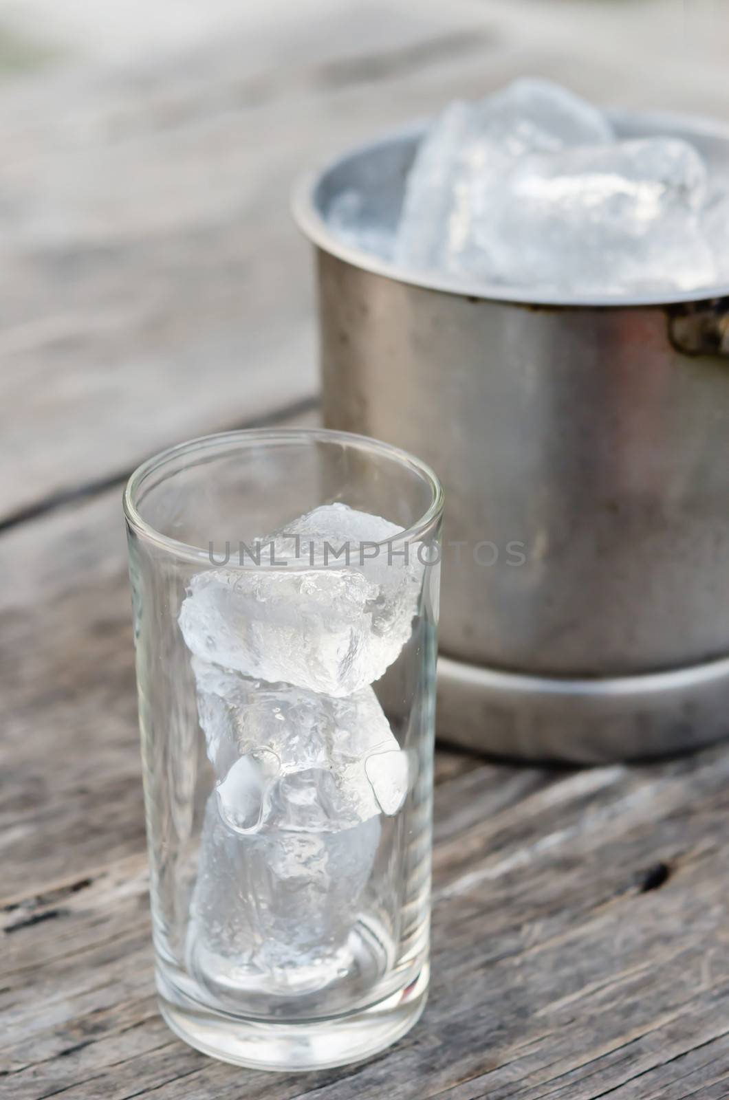 Glass with ice cubes and Ice bucket filled with ice cubes