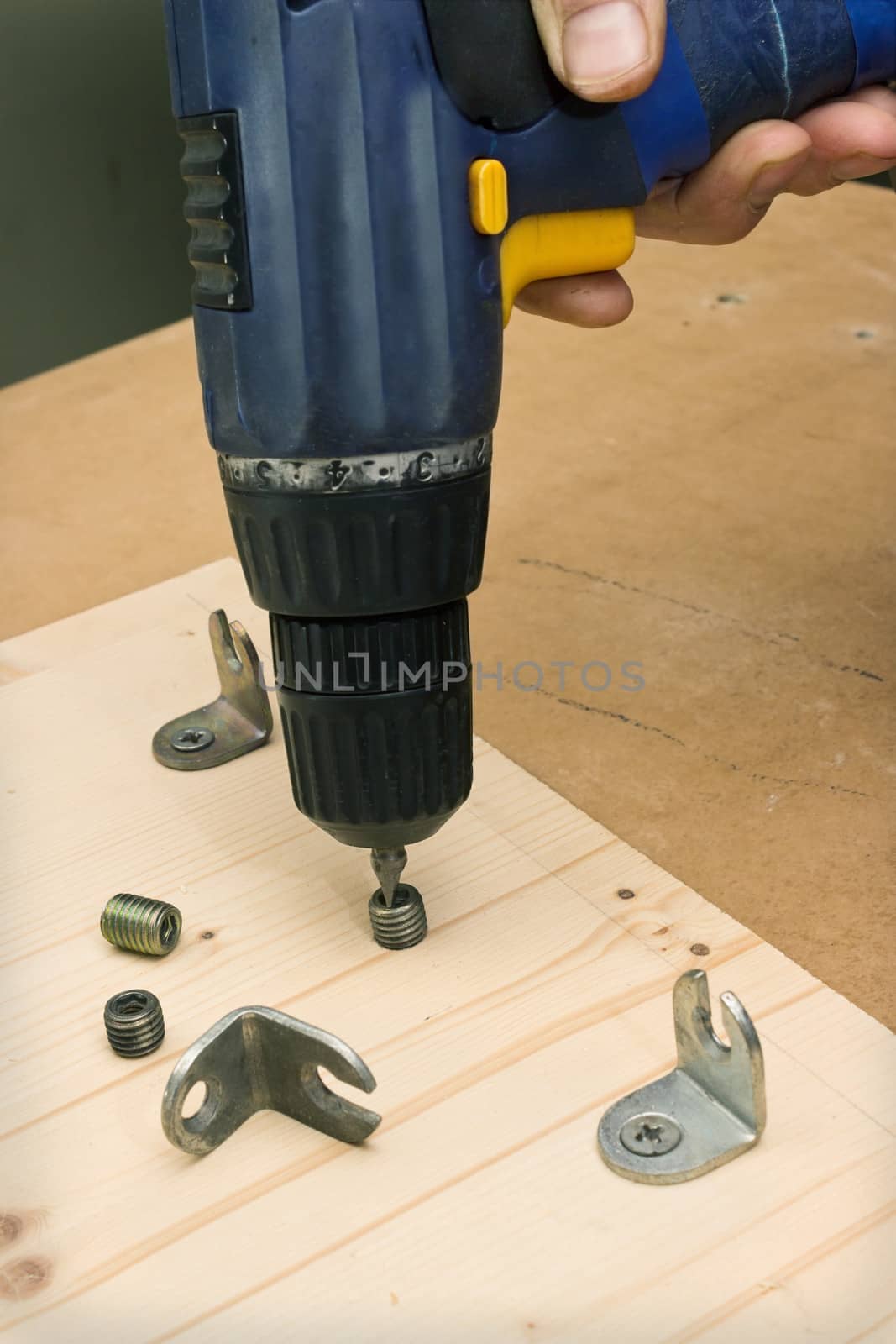 Fastening with an electric screwdriver furniture parts in production of furniture