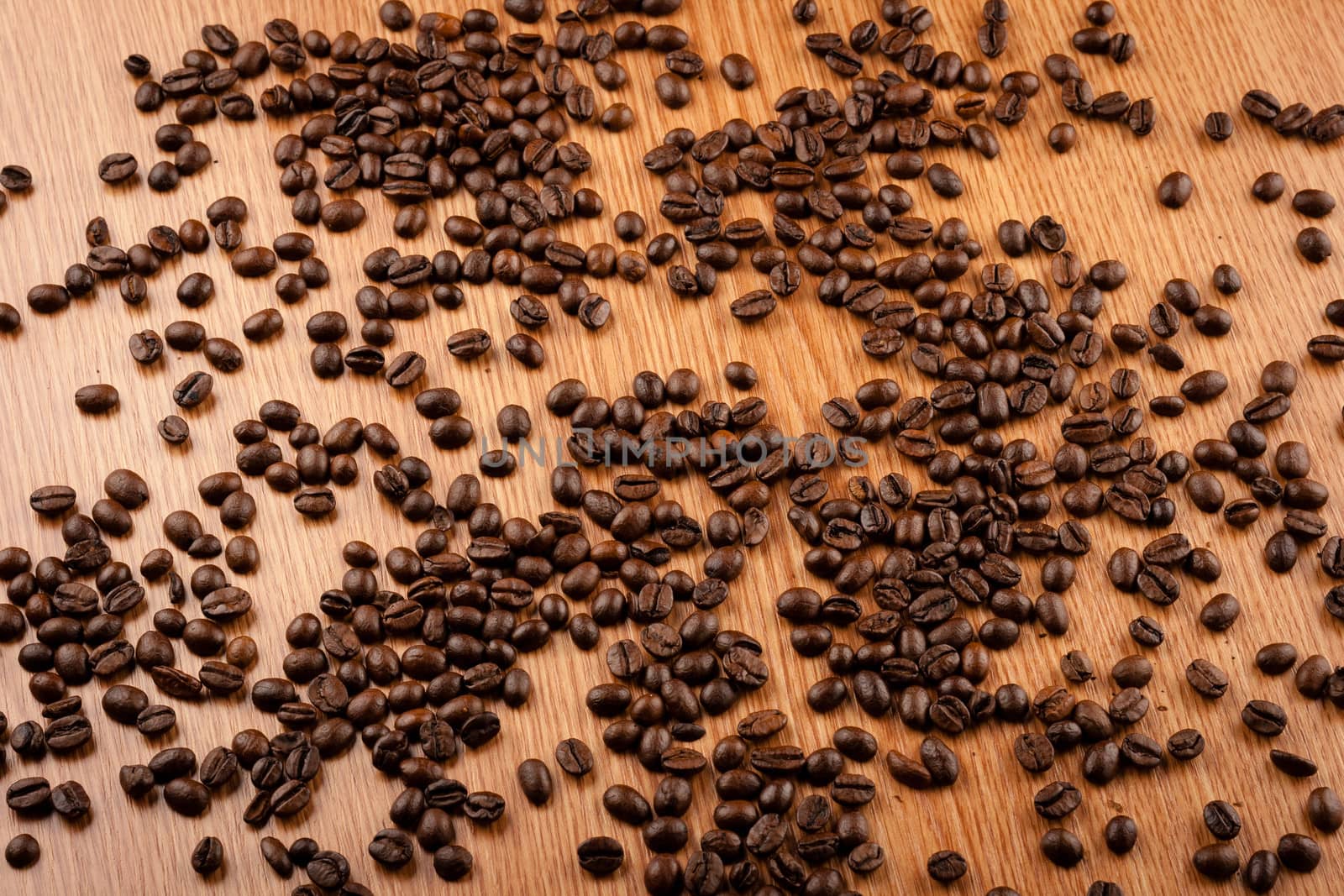 Scattered coffee beans on wooden table