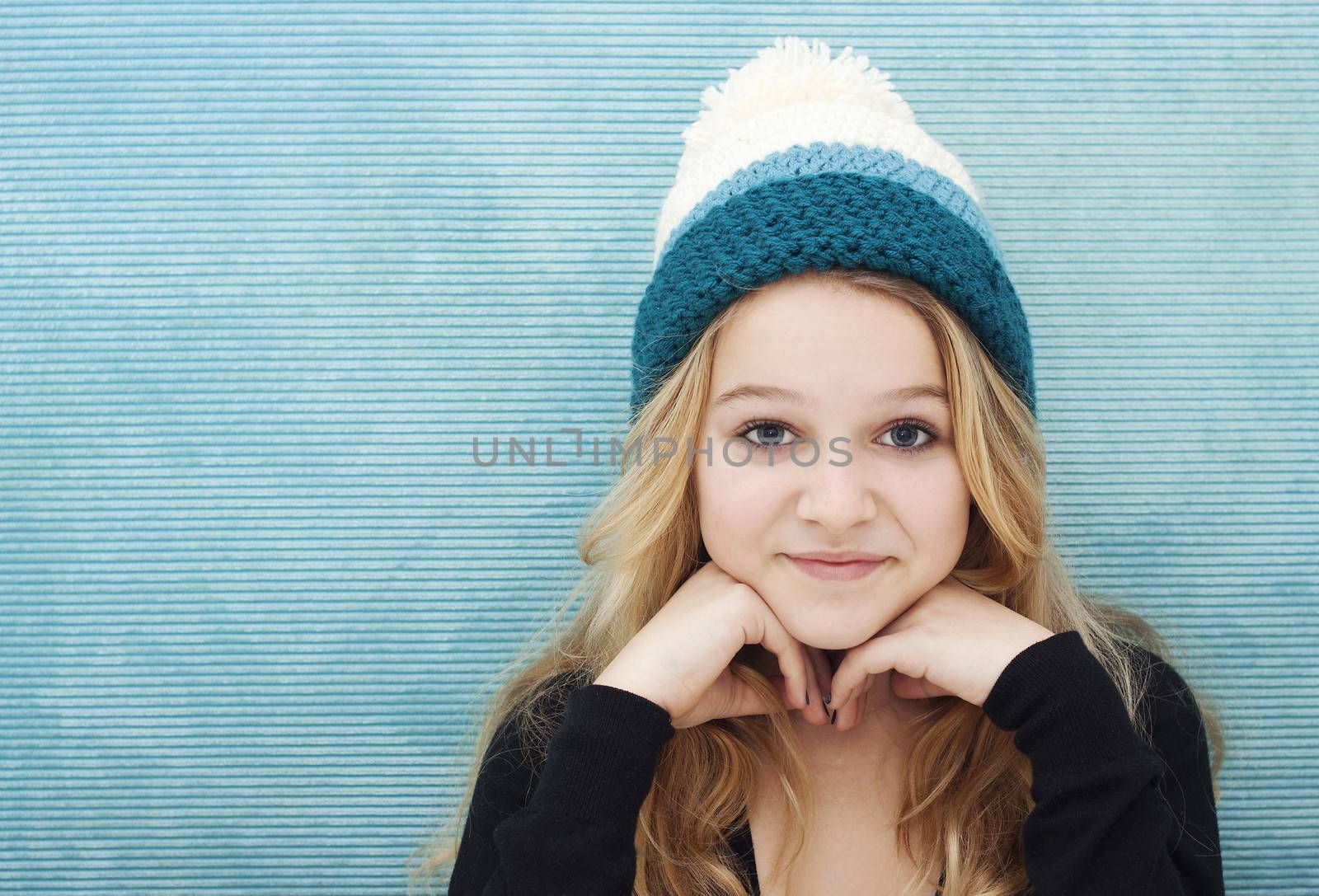 Girl with long blond hair and woolly cap space for text