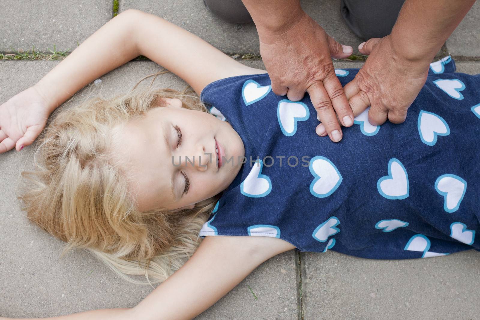 A little girl receiving first aid heart massage by nurse or doctor or paramedic