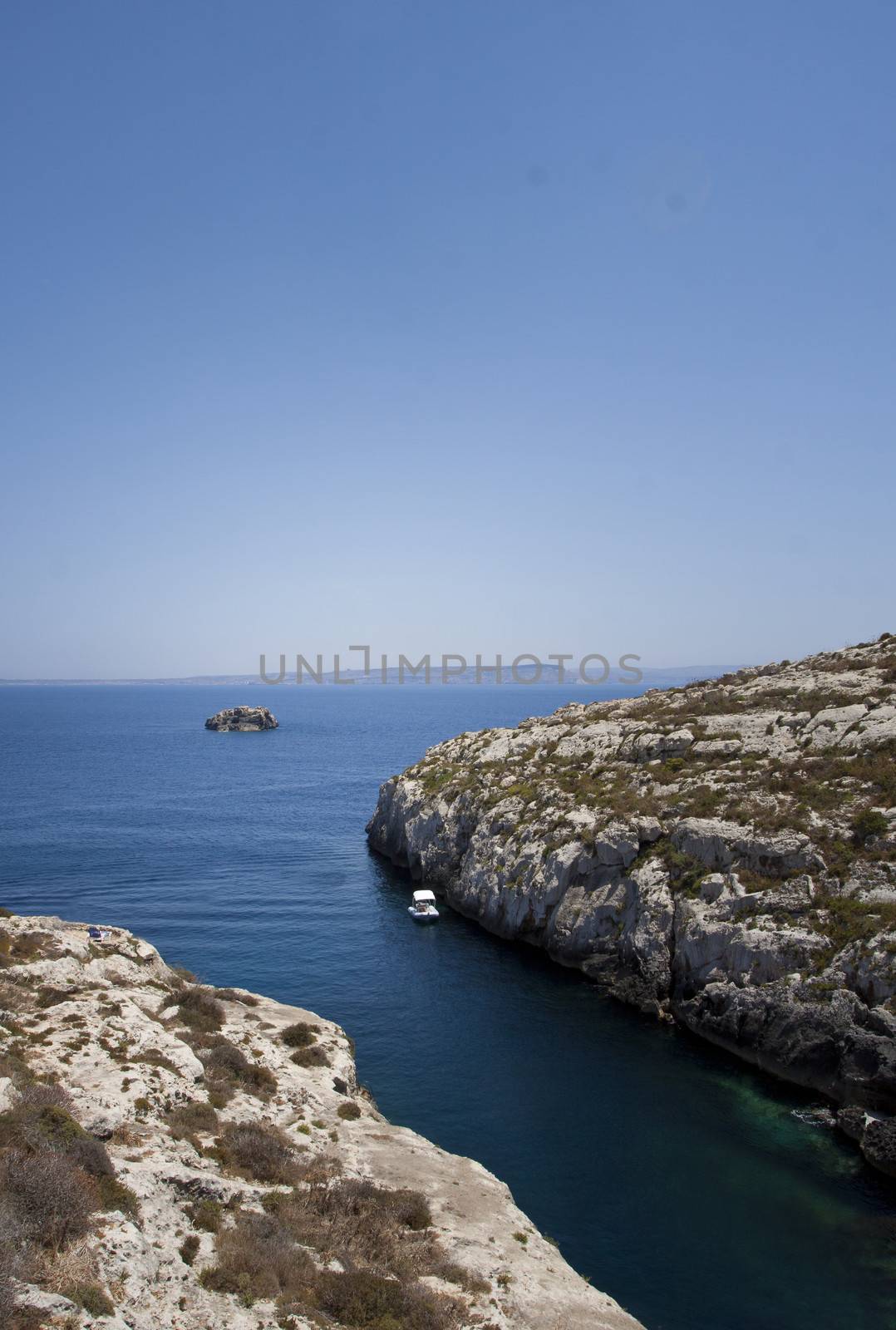 Gozo,Maltese coastline with the cliffs,gold rocks over the sea in Malta island with the blue clear sky background