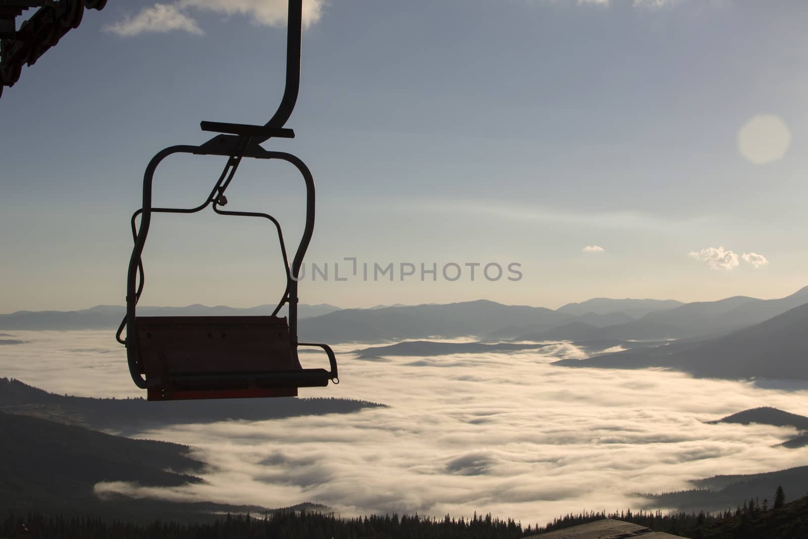 Seat elevator in the mountains above the white clouds
