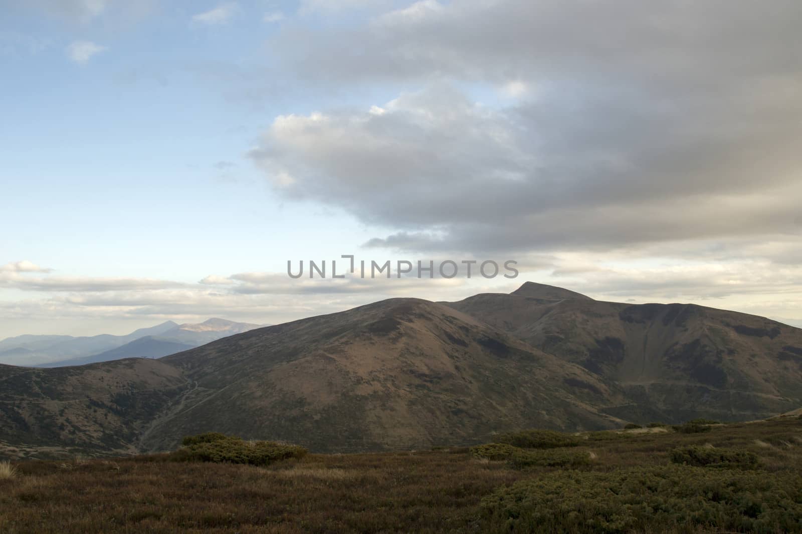 Mountain peaks in the autumn evening sky with clouds