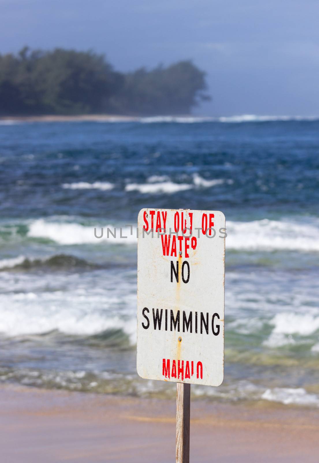 Warning sign no swimming in treacherous winter waters on Tunnels Beach in Kauai Hawaii