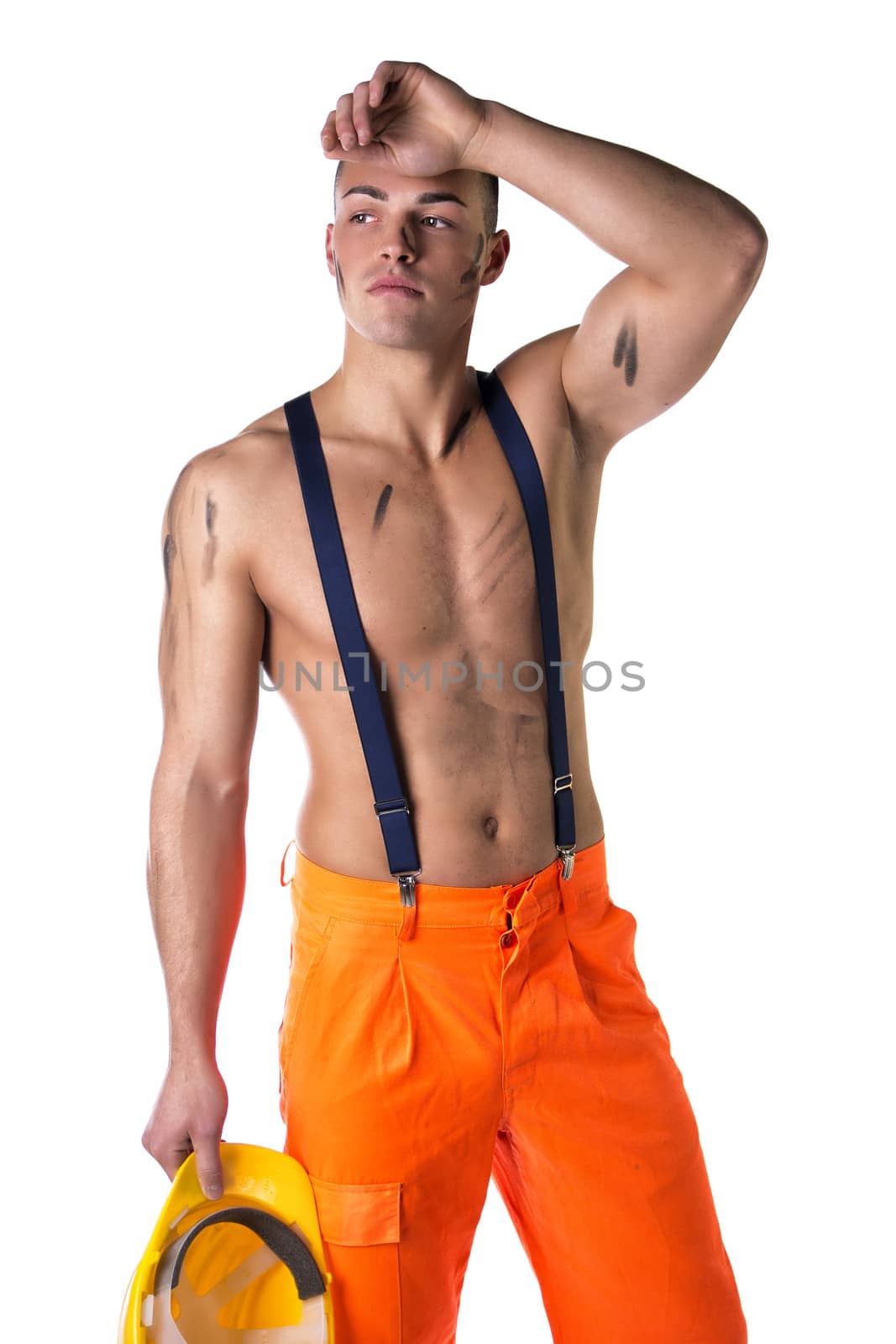 Handsome young construction worker with naked torso, wearing yellow hardhat