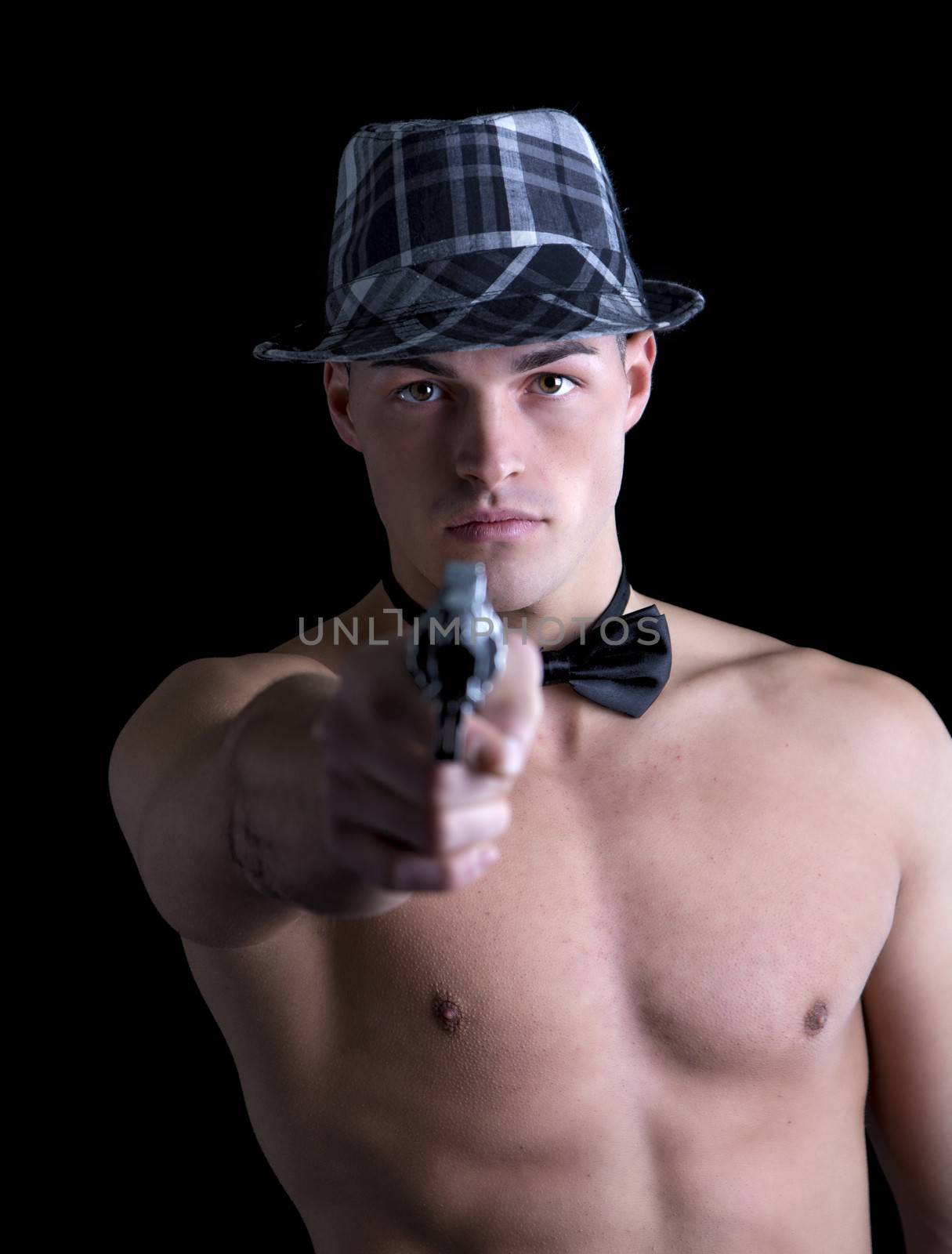 Attractive shirtless young man with black bow-tie and grey fedora hat pointing gut at camera