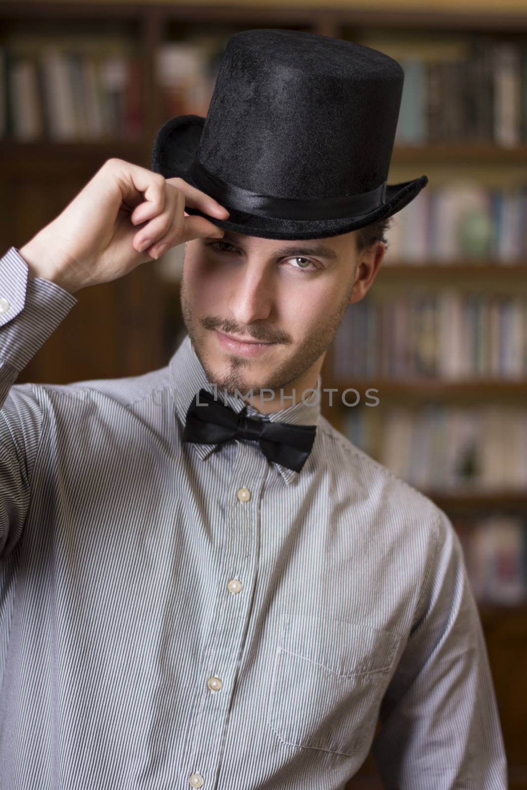 Attractive young man wearing top hat and bow tie by artofphoto