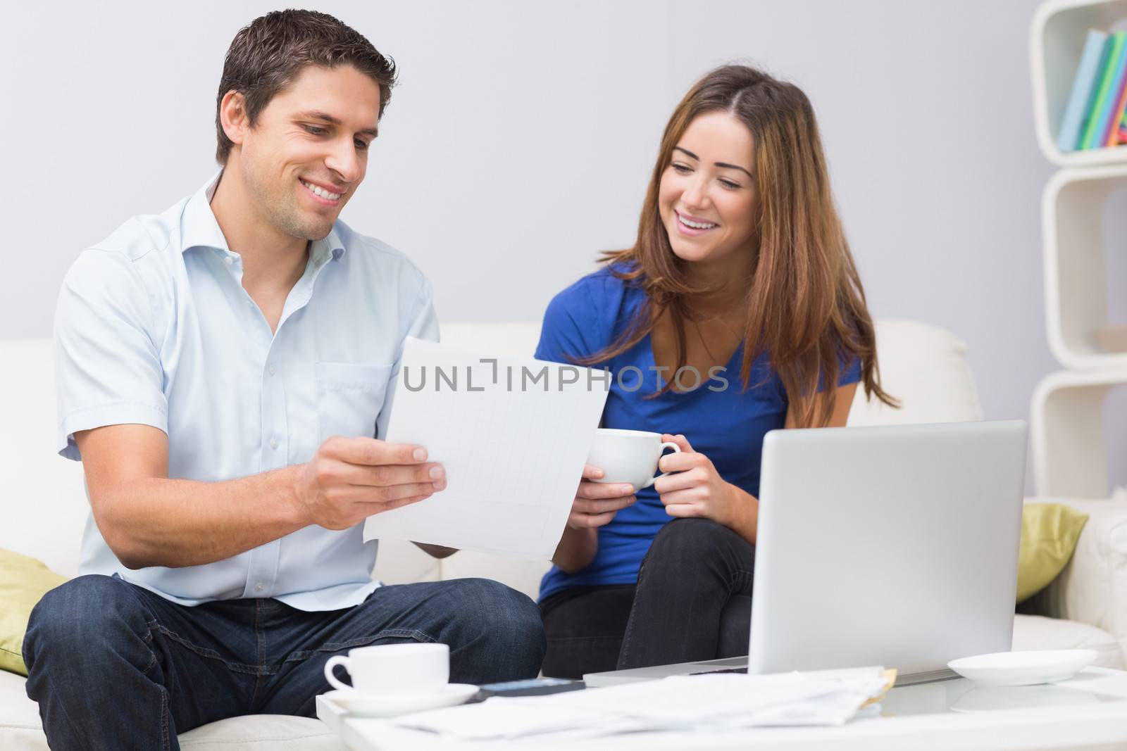 Couple paying their bills online at home by Wavebreakmedia