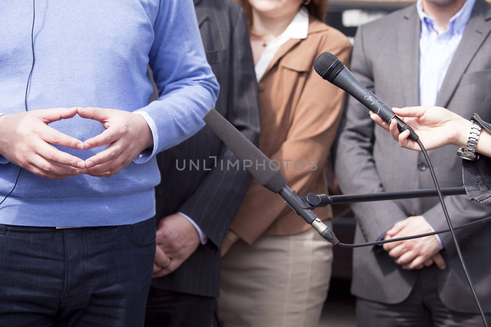 Journalist hand holding a microphone conducting an TV or radio interview