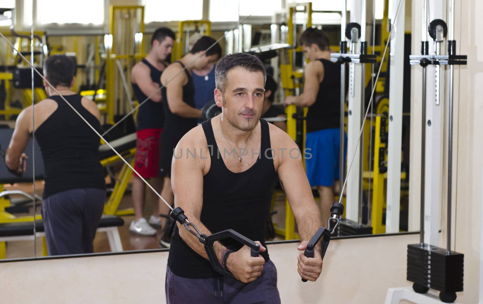 Middle aged man working out with gym equipment by artofphoto